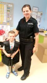 Zdjęcie przedstawia funkcjonariuszkę KAS wraz z małym dzieckiem w kamizelce służbowej