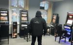 Na zdjęciu funkcjonariusz Służby Celno-Skarbowej w nielegalnym salonie gier. Widoczne automaty do gier.