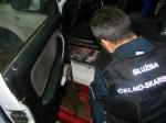 Na zdjęciu funkcjonariusz celno-skarbowy wyjmuje ukryte w samochodzie papierosy