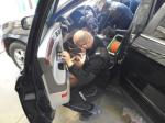 Na zdjęciu funkcjonariusz celno-skarbowy rozcina samochód by wydobyć ukryte papierosy