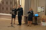 Funkcjonariusz i dwie Funkcjonariuszki Służby Celno-Skarbowej śpiewają wspólnie przez mikrofony.