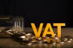 Napis VAT na tle monet