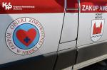 Drzwi ambulansu z logo Zakład Opieki Zdrowotnej w Nidzicy.