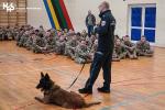 Funkcjonariusz Służby Celno-Skarbowej z psem służbowym prowadzi zajęcia dla uczniów klas mundurowych.