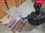Funkcjonariuszka Służby Celno-Skarbowej siedzi przy kartonach z papierosami
