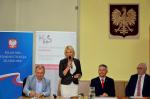 Zdjęcie przedstawia przedstawicielkę Marszałka Województwa Warmińsko-Mazurskiego składającą gratulacje podczas spotkania